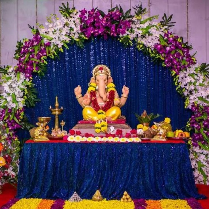 Ganpati altar with orchids and a blue shimmer backdrop