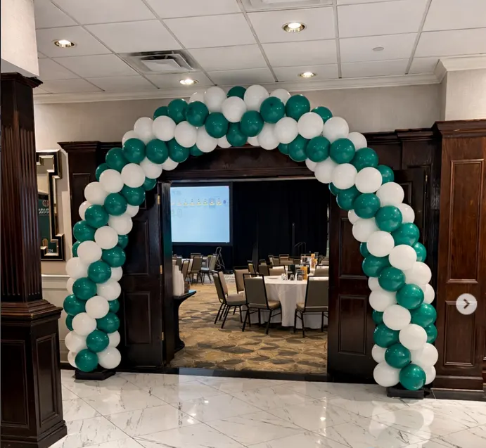 Green and white balloon arch at a corporate event entrance